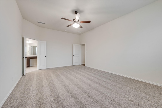 unfurnished bedroom with ceiling fan, ensuite bathroom, and light carpet