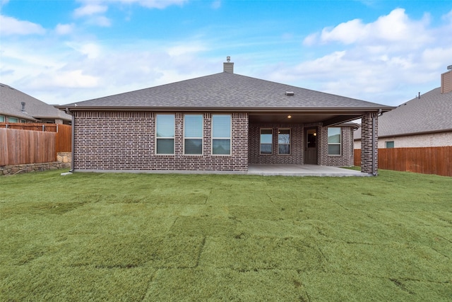 rear view of property featuring a lawn and a patio