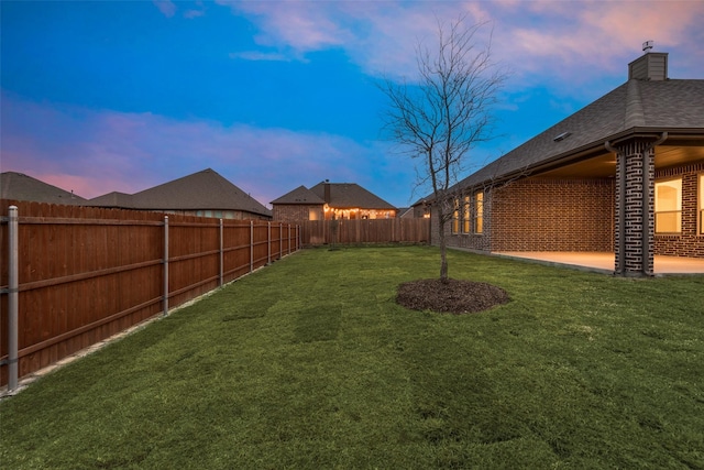 yard at dusk featuring a patio area