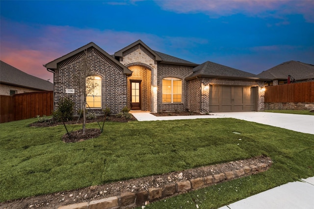 view of front of house with a garage and a lawn