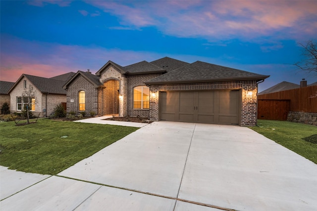 view of front of house featuring a garage and a yard