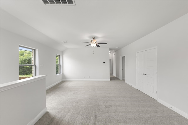 empty room featuring light carpet, lofted ceiling, and ceiling fan