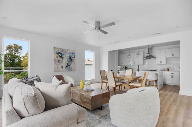 living room featuring ceiling fan and light hardwood / wood-style floors