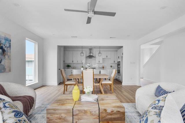 dining space with light wood-type flooring and ceiling fan