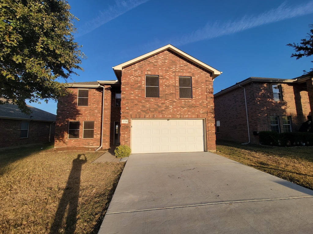 view of property with a front lawn and a garage