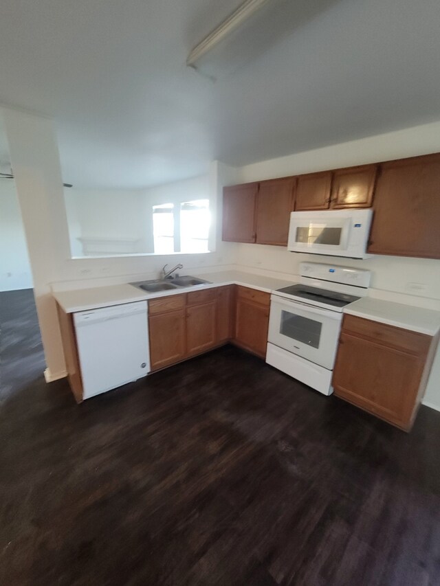 kitchen with sink, dark wood-type flooring, and white appliances