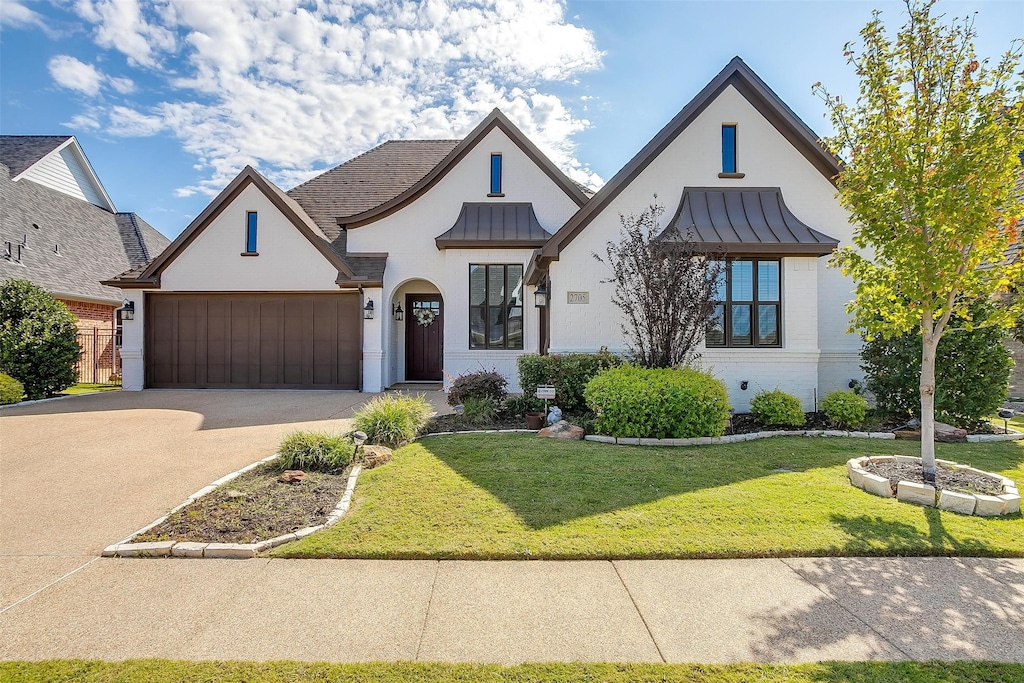 view of front of home with a garage and a front lawn