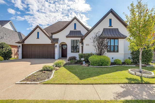 view of front of home with a garage and a front lawn