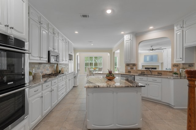 kitchen featuring tasteful backsplash, sink, a center island, stainless steel appliances, and white cabinets