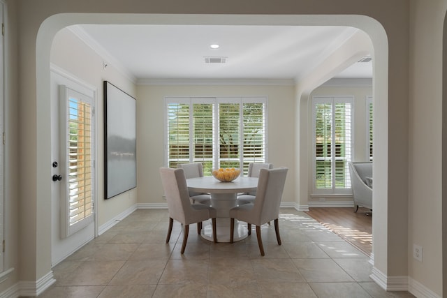 tiled dining area featuring crown molding and a wealth of natural light