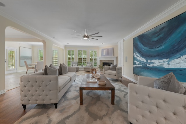 living room featuring ornamental molding, wood-type flooring, and ceiling fan