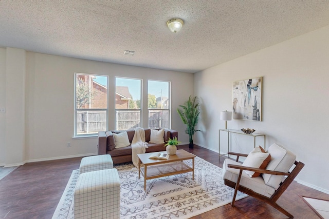 living room featuring dark wood-type flooring and a textured ceiling