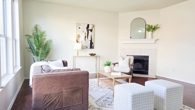 living room featuring a textured ceiling, a fireplace, and dark hardwood / wood-style floors