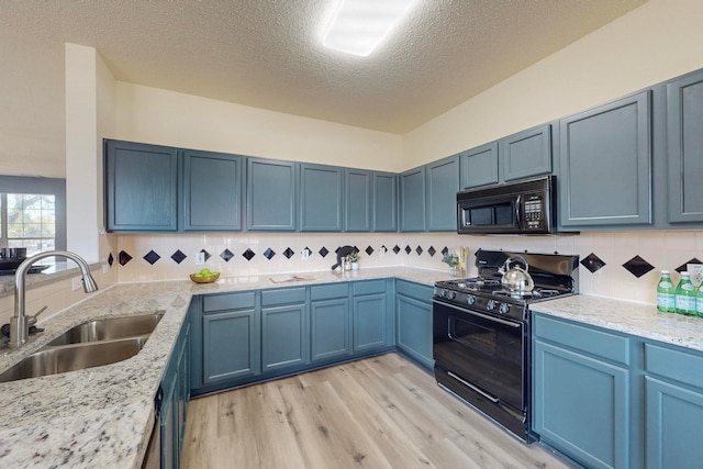 kitchen with black appliances, sink, backsplash, blue cabinets, and light hardwood / wood-style flooring