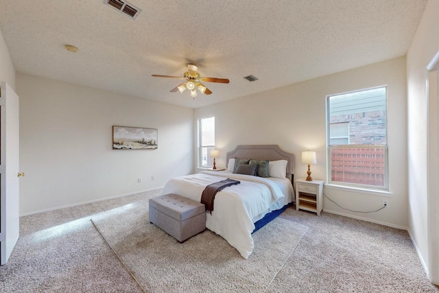 carpeted bedroom featuring a textured ceiling and ceiling fan