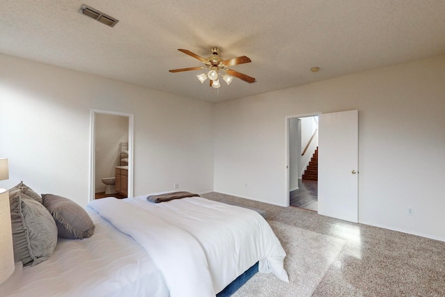 bedroom featuring a textured ceiling, ensuite bathroom, and ceiling fan