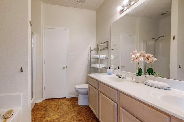 bathroom with vanity, toilet, a textured ceiling, and a shower with door