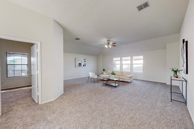 interior space with light carpet, a textured ceiling, lofted ceiling, and ceiling fan