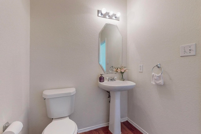 bathroom with toilet and wood-type flooring