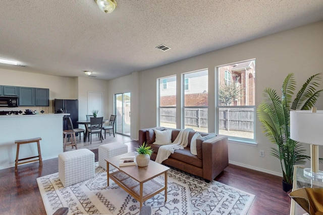 living room with a textured ceiling and dark wood-type flooring