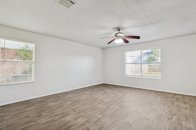 unfurnished room featuring a textured ceiling, light wood-type flooring, and ceiling fan