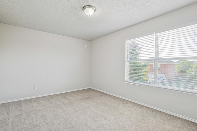 carpeted spare room featuring a textured ceiling