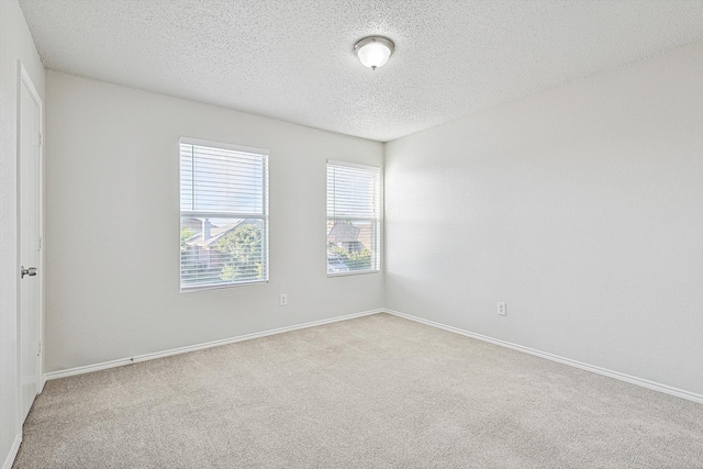 carpeted empty room featuring a textured ceiling