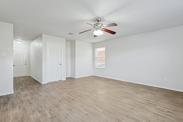 unfurnished room featuring a textured ceiling, light wood-type flooring, and ceiling fan