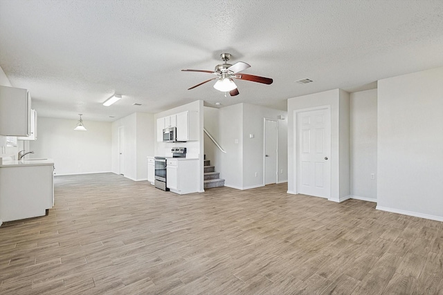 2121 Franks St, Fort Worth, TX 76177 - unfurnished living room featuring a textured ceiling, ceiling fan, light wood-type flooring, baseboards, and stairway