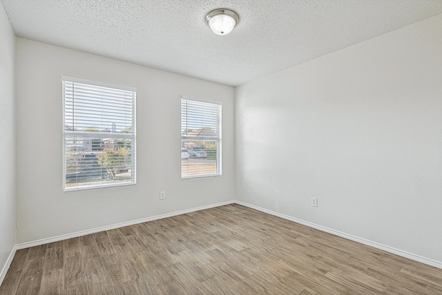 spare room featuring a textured ceiling and light wood-type flooring