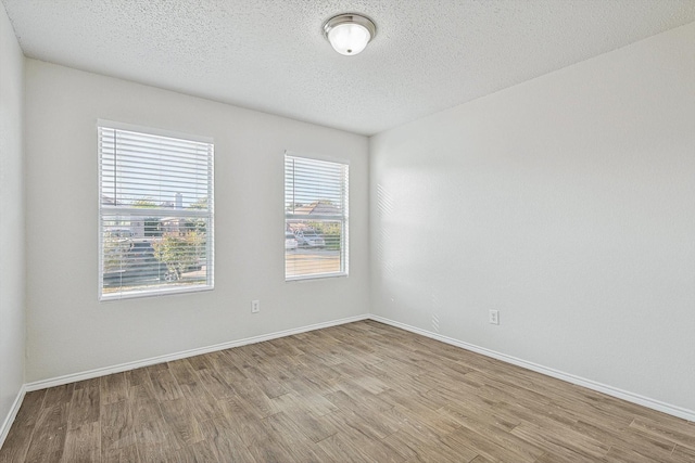 2121 Franks St, Fort Worth, TX 76177 - empty room with wood finished floors, baseboards, and a textured ceiling