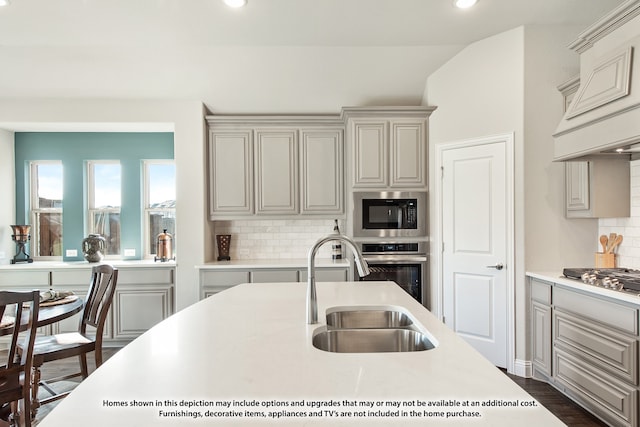 kitchen featuring lofted ceiling, tasteful backsplash, appliances with stainless steel finishes, premium range hood, and dark hardwood / wood-style floors