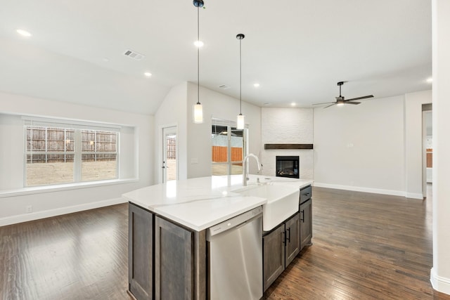 kitchen featuring a large fireplace, plenty of natural light, dishwasher, open floor plan, and a sink