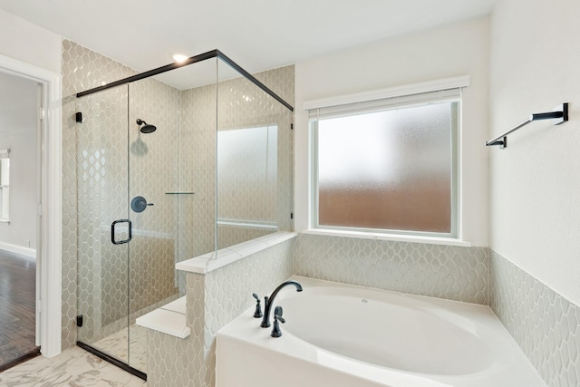 bathroom with a shower stall and a bath