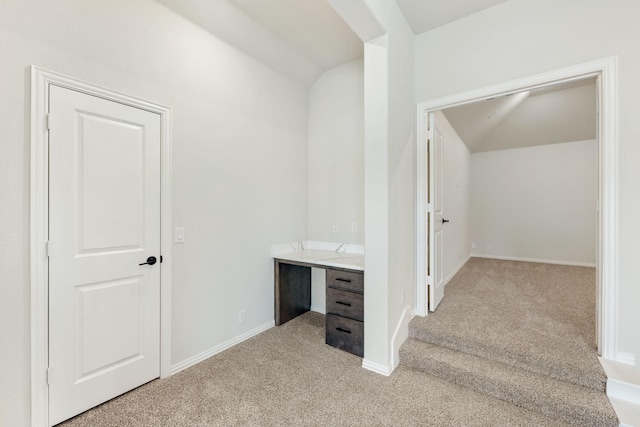 interior space featuring vaulted ceiling and baseboards