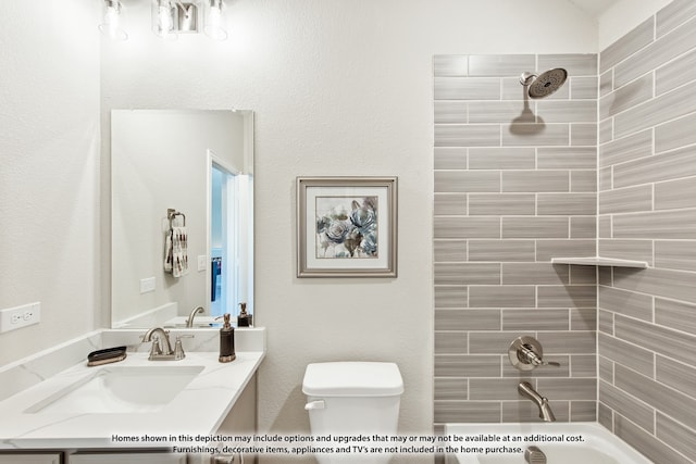 full bathroom featuring toilet, tiled shower / bath, and vanity