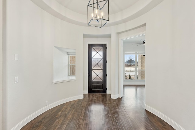 foyer entrance with baseboards, a chandelier, and dark wood-style flooring