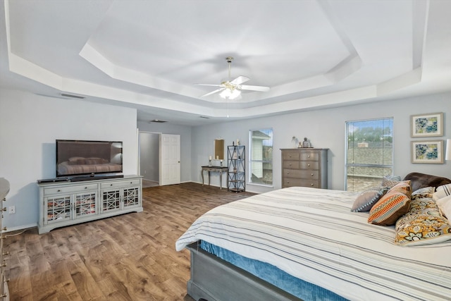 bedroom featuring ceiling fan, a tray ceiling, and hardwood / wood-style floors