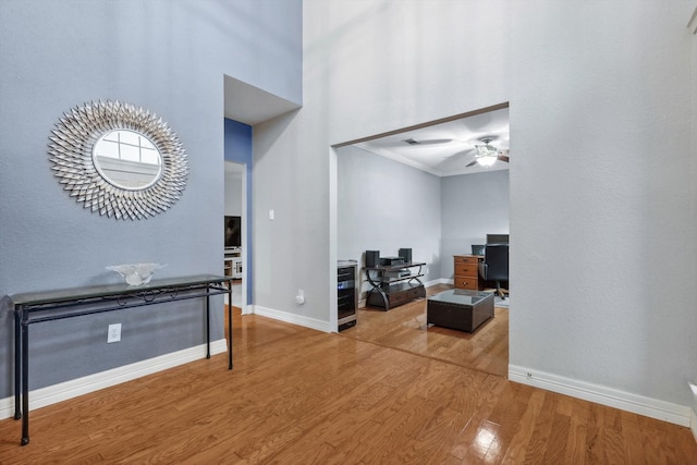 interior space with ornamental molding, hardwood / wood-style flooring, and a high ceiling