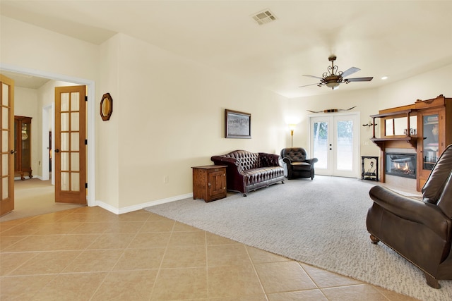 living room featuring light colored carpet, french doors, and ceiling fan