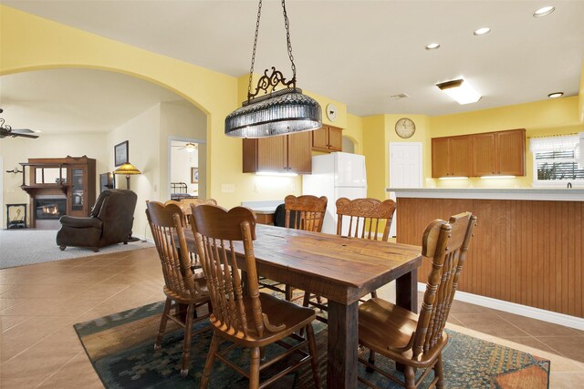 502 Smith Oak Rd, Sherman, TX 75090 - tiled dining room featuring arched walkways, recessed lighting, a glass covered fireplace, and ceiling fan