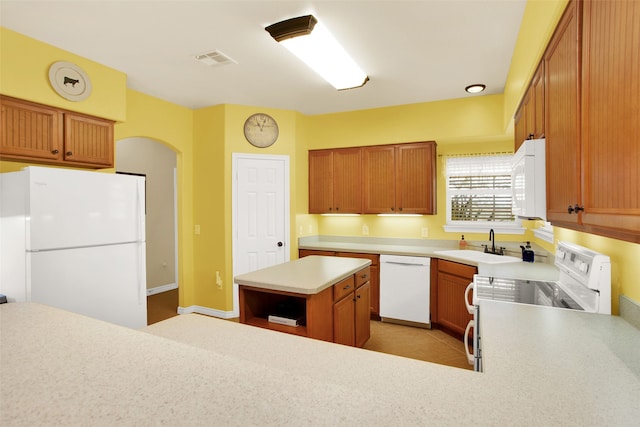 kitchen featuring sink, white appliances, and a center island