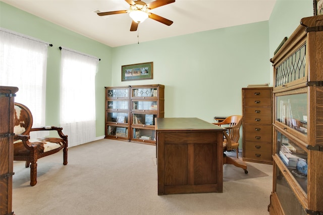 carpeted office space featuring ceiling fan