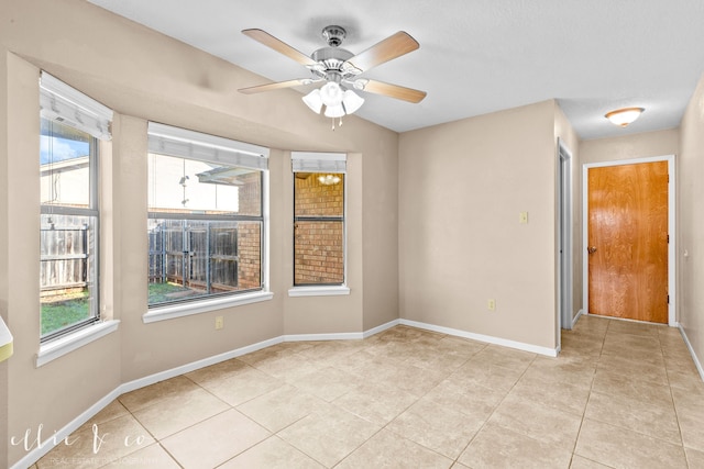 tiled spare room featuring a wealth of natural light and ceiling fan