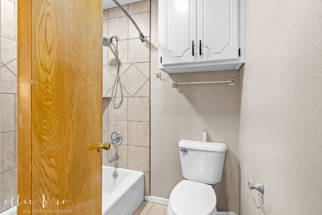 bathroom featuring tiled shower / bath, toilet, and tile patterned flooring