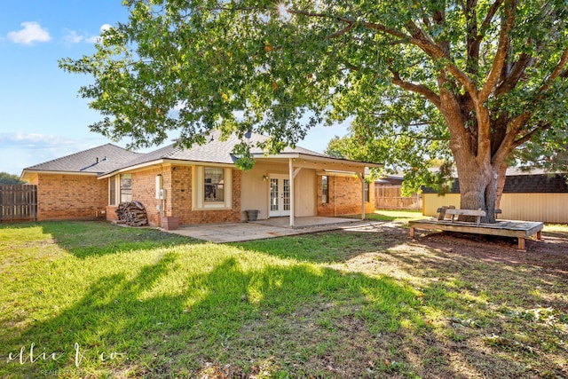 back of house featuring french doors, a patio area, and a lawn