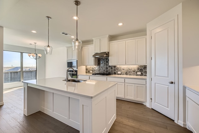 kitchen featuring white cabinets, dark hardwood / wood-style flooring, stainless steel microwave, and sink