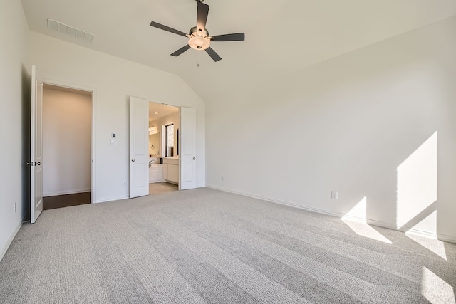 unfurnished bedroom with light carpet, ensuite bath, ceiling fan, and lofted ceiling