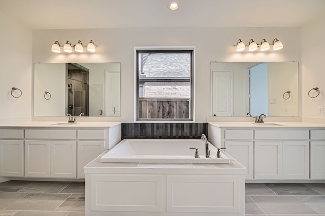 bathroom featuring vanity and independent shower and bath