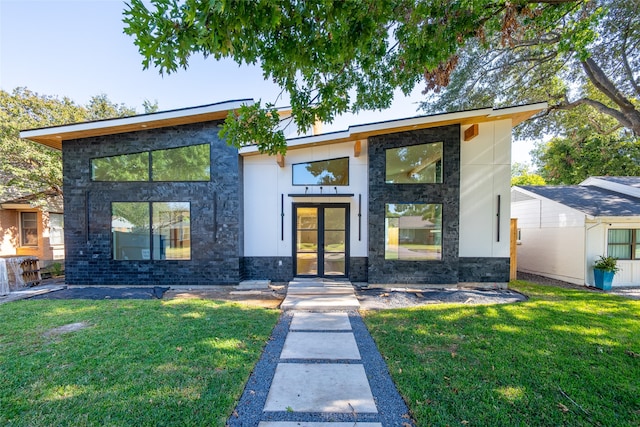 contemporary home with a front yard and french doors